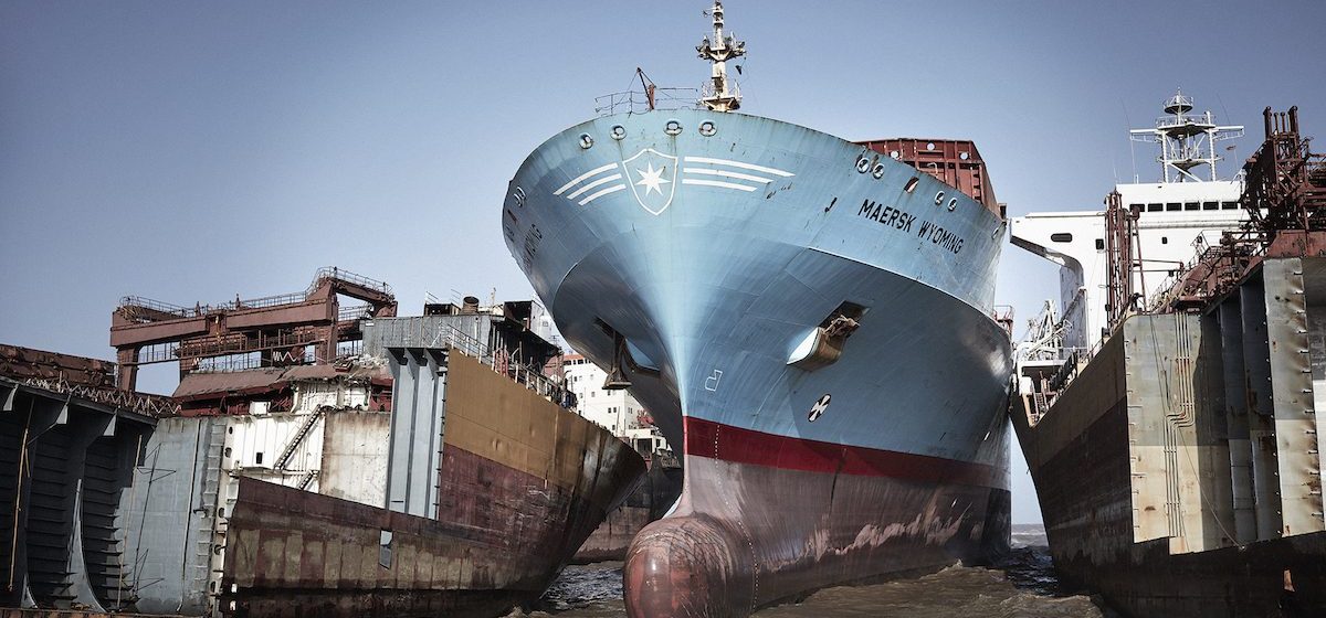 Een containerschip van Maersk op het sloopstrand van Alang